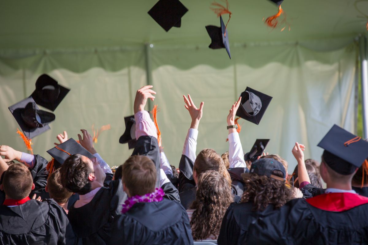 Graduation caps tossed in the air during a real ceremony